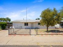 Charming single-story home featuring a white exterior, fenced yard, and mature shade tree at 2834 E Michael Dr, Phoenix, AZ 85032