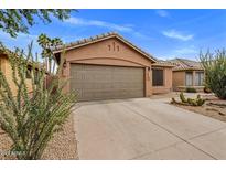 Home exterior showcasing a two-car garage, desert landscaping and a neutral color scheme at 3353 E Blackhawk Dr, Phoenix, AZ 85050