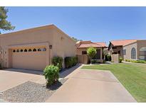 Inviting beige single story home featuring a two car garage and well manicured lawn at 4039 E Paradise Dr, Phoenix, AZ 85028