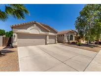 Inviting home with a spacious three-car garage, tile roof, and well-kept landscaping at 6958 W Morning Dove Dr, Glendale, AZ 85308