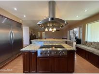 Gourmet kitchen featuring a central island with a cooktop and granite countertops at 9221 N 48Th Dr, Glendale, AZ 85302