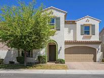Inviting two-story home with stucco exterior, arched front entry, lush tree, and two-car garage at 970 W Zion Way, Chandler, AZ 85248