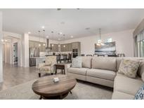 Bright, open living room with modern decor flowing seamlessly into a stylish kitchen and dining area at 1026 N 152Nd Ave, Goodyear, AZ 85338
