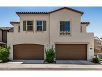Two-story home with brown garage doors, stucco exterior, and decorative window accents at 1153 W Diamondback Dr, Chandler, AZ 85286