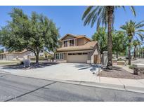 Two-story home with a terra cotta roof, large driveway, mature trees, and desert landscaping at 1311 N Congress Dr, Chandler, AZ 85226