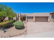 Beige house featuring a three-car garage, desert landscaping, rock detail and a charming desert tree in the front yard at 14806 E Lookout Ledge --, Fountain Hills, AZ 85268