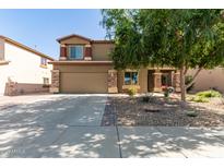 Charming two-story home with a large driveway, desert landscaping, and stone accents on the facade at 17753 W Columbine Dr, Surprise, AZ 85388