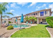 Inviting backyard featuring a refreshing pool, lush greenery, and a charming patio area perfect for outdoor entertaining at 21167 E Aspen Valley Dr, Queen Creek, AZ 85142