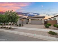 Charming home featuring a three car garage, a brick driveway, and desert landscaping in front at 21934 E Lords Ct, Queen Creek, AZ 85142