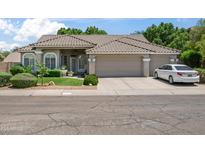Charming single-story home featuring a tile roof, three-car garage, and manicured front yard at 2243 E Cortez Dr, Gilbert, AZ 85234