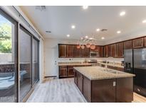 Modern kitchen boasts stainless steel appliances, granite counters, and an island with a sink at 2275 N Heritage St, Buckeye, AZ 85396
