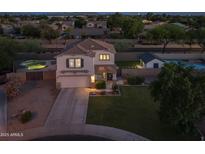 Inviting two-story home featuring a well-manicured lawn, attached garage, and private backyard pool, perfect for outdoor entertainment at 2661 E Los Alamos Ct, Gilbert, AZ 85295