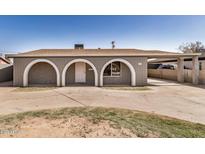 Charming home exterior features arched entryways, a covered carport, and a spacious front yard at 3441 E Taylor St, Phoenix, AZ 85008