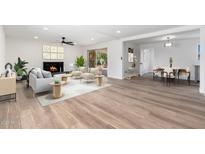 Bright open-concept living room with fireplace, wood-look flooring, neutral palette, and ample natural light at 3822 W Flower St, Phoenix, AZ 85019