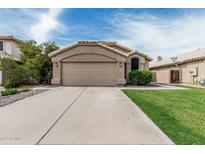 Charming single-story home with a well-manicured lawn and a two-car garage at 3856 E Encinas Ave, Gilbert, AZ 85234