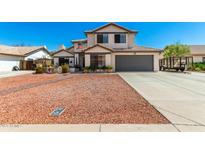 Charming two-story home with a well-manicured front yard, and a two car garage at 7749 W Hearn Rd, Peoria, AZ 85381