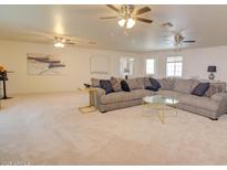 Bright living room featuring a large sectional sofa and multiple ceiling fans for added comfort at 809 N Gilbert Ave, Casa Grande, AZ 85122