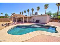 Sparkling pool in a private backyard setting, complete with palm trees and a covered patio area at 809 N Gilbert Ave, Casa Grande, AZ 85122