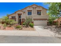 Two-story home boasts desert landscaping, a neutral color palette, and a three-car garage at 9661 E Glencove Cir, Mesa, AZ 85207