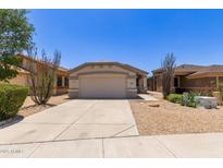 Charming single-story home featuring a two-car garage, desert landscaping, and a welcoming facade under a clear blue sky at 9717 W Purdue Ave, Peoria, AZ 85345