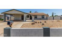 Charming single-story home with a covered carport, xeriscaped yard and painted decorative block wall at 9801 N 56Th Dr, Glendale, AZ 85302