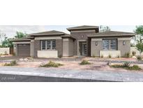 Stunning single-story home featuring a stylish mix of stucco and stone, well-maintained desert landscaping and an attached two-car garage at 10024 S 38Th Ln, Laveen, AZ 85339