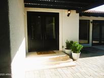 Inviting front entrance features a double door, well-maintained landscaping, and neutral stone pavers at 2068 E Cairo Dr, Tempe, AZ 85282