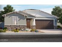 Charming single-story home featuring stone accents, a two-car garage, and professionally landscaped front yard at 24448 W Grenadine Rd, Buckeye, AZ 85326