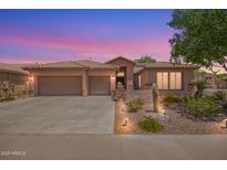 Charming home featuring a tile roof, three-car garage, and professionally landscaped desert-style yard at 25633 N 71St Dr, Peoria, AZ 85383