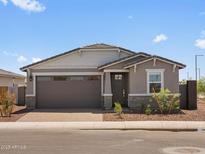 Charming single-story home with a well-maintained front yard and a two car garage at 5573 S 246Th Ave, Buckeye, AZ 85326
