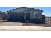 Charming single-story home featuring a two-car garage and a well-maintained front yard at 5573 S 246Th Ave, Buckeye, AZ 85326