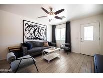Stylish living room features a gray sofa, accent chairs, and modern art at 6012 W Flower St, Phoenix, AZ 85033