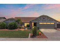 Charming single-story home featuring manicured landscaping, warm exterior lighting, and a welcoming two-car garage at 7649 W Dahlia Dr, Peoria, AZ 85381