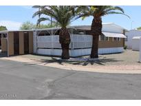 Cozy home featuring mature palm trees and a charming lattice-enclosed porch area at 9501 E Broadway Rd # 254, Mesa, AZ 85208