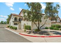 Two-story home with a stucco facade, clay tile roof, and a three-car garage and mature landscaping at 11011 N 92Nd St # 1005, Scottsdale, AZ 85260
