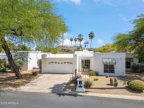 Inviting home featuring desert landscaping, a two-car garage, and charming black and white striped awnings at 113 E Boca Raton Rd, Phoenix, AZ 85022