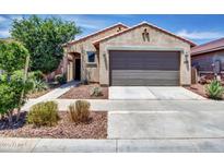 Charming single-Gathering home featuring a neutral-toned facade, low maintenance landscape, and an attached two-car garage at 14160 W Georgia Dr, Surprise, AZ 85379