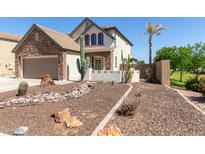 Charming two-story home featuring desert landscaping, a stone facade, and a two-car garage at 14895 W Jenan Dr, Surprise, AZ 85379