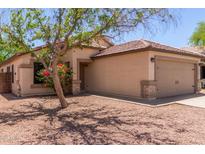 Charming single-story home with a well-maintained yard and neutral stucco exterior at 14919 W Hearn Cir, Surprise, AZ 85379
