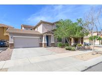 Charming two-story home with a two-car garage, desert landscaping, and a covered front porch at 15450 W Laurel Ln, Surprise, AZ 85379
