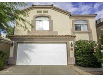 Two story home with a white garage door, desert landscaping, and a beige exterior paint at 20221 N 31St St, Phoenix, AZ 85050