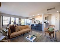 Inviting living room with stylish sofa, open floor plan, and modern kitchen with breakfast bar at 2201 N Central Ave # 3C, Phoenix, AZ 85004