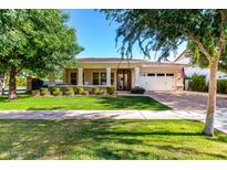 Charming single-story home with a well-manicured lawn and inviting front porch with white columns at 2879 E Austin Dr, Gilbert, AZ 85296