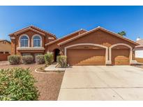 Two-story home with a three-car garage and desert landscaping at 3424 E Harmony Ave, Mesa, AZ 85204