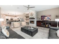 Open-concept living room featuring a fireplace and views of the modern kitchen area at 5428 E Windstone Trl, Cave Creek, AZ 85331