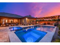 Inviting backyard pool and spa with outdoor seating, a fire pit, and a pergola at dusk at 5428 E Windstone Trl, Cave Creek, AZ 85331