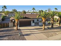 Charming single-story home with desert landscaping, mature palm trees, and a spacious two-car garage at 5802 E Spring Rd, Scottsdale, AZ 85254