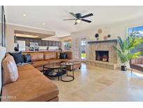 Spacious living room with a stone fireplace and light-filled views of the exterior at 6819 E Sheena Dr, Scottsdale, AZ 85254