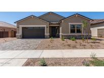 Charming single-story home featuring a two-car garage and desert landscaping at 15833 W Bronco Trl, Surprise, AZ 85387