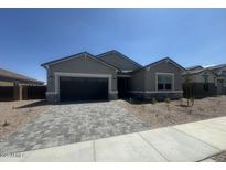 Charming single-story home featuring stone accents and a paver driveway at 15833 W Bronco Trl, Surprise, AZ 85387